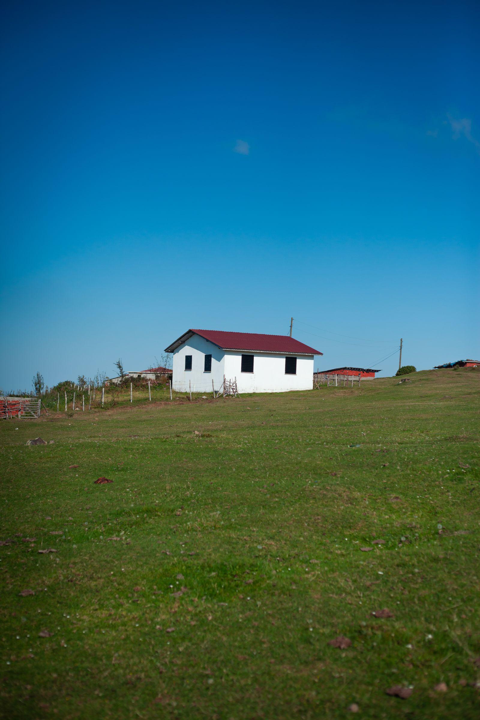 A rural home standing in an open field